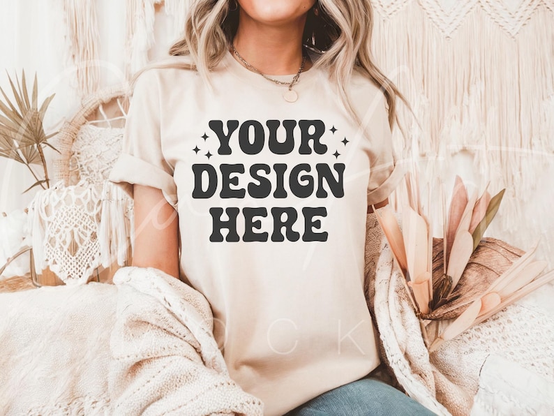 May include: A beige t-shirt with the text "YOUR DESIGN HERE" in black retro-style lettering.