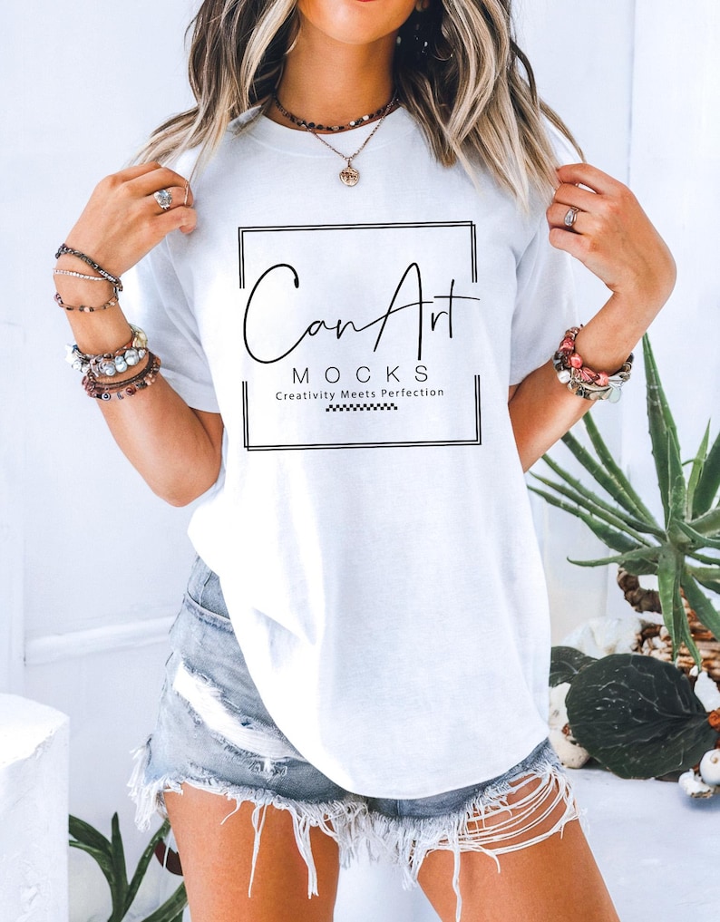Comfort Colors white oversized t-shirt mockup with a relaxed fit, styled with distressed denim in a bright modern setting, perfect for showcasing custom designs.