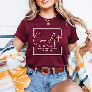 Pode incluir: Uma camiseta vinho com um gr&aacute;fico quadrado branco que diz "Can Art Mocks" e "Creativity Meets Perfection".