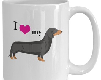 May include: White ceramic coffee mug with a black and tan dachshund silhouette and the text "I love my" with a pink heart.