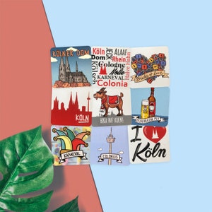 以下が含まれることがあります： ケルン、ドイツに関連するさまざまな画像とテキストが描かれた、カラフルなコースター8枚セット。コースターには、ケルン大聖堂、伝統的なドイツのビアジョッキ、道化師、ヤギ、そして「ケルンが大好き」というテキストが書かれたハートが描かれています。コースターには、「ケルナー・ドーム」、「ボック・アウフ・ケルン」、「カルナバル」など、ドイツ語のテキストも書かれています。