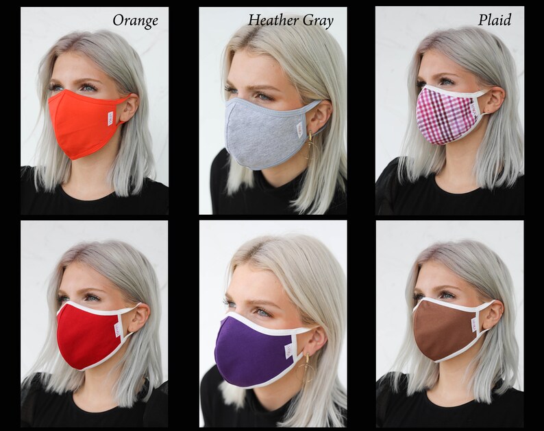 May include: Six different face masks with white trim, shown on six different models with blonde hair. The masks are in the colors orange, heather gray, plaid, red, purple, and brown.