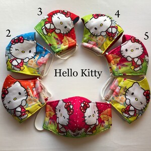 May include: Six Hello Kitty face masks in different colors and patterns. The masks are numbered 1 through 6. The masks are all made of fabric and have a white elastic band.