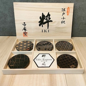 May include: A set of six black and gold Japanese-style plates with different geometric patterns, packaged in a wooden box with the text "Edo-Komon" and "粋 IKI" on the lid.