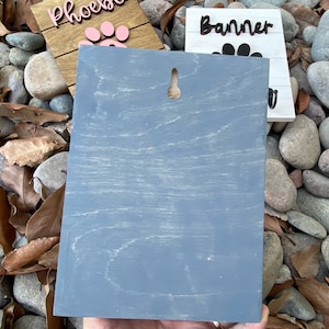 K&ouml;nnte beinhalten: Ein graues Holzschild mit einem Loch oben zum Aufh&auml;ngen. Das Schild ist leer und kann personalisiert werden.