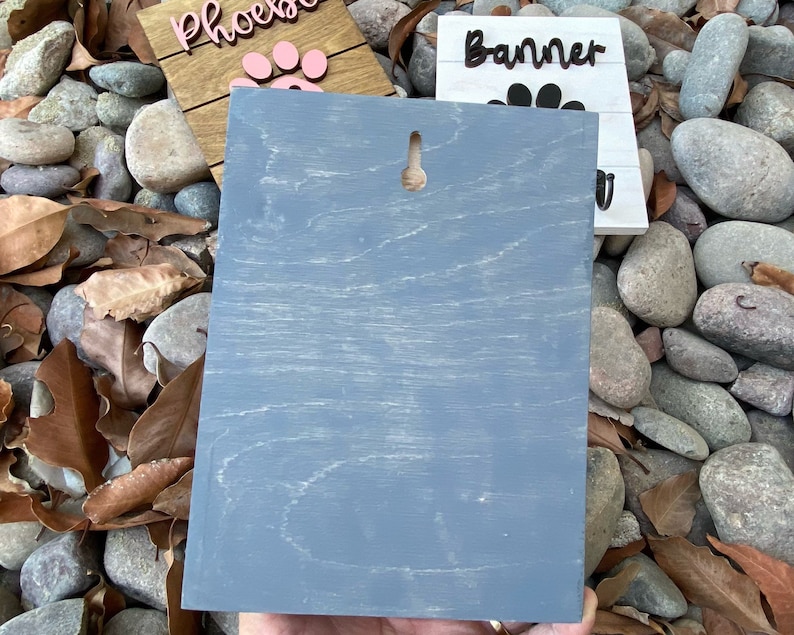 K&ouml;nnte beinhalten: Ein graues Holzschild mit einem Loch oben zum Aufh&auml;ngen. Das Schild ist leer und kann personalisiert werden.