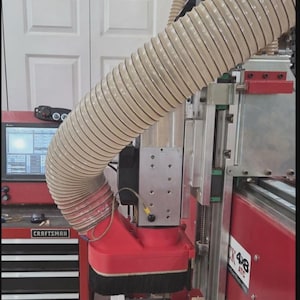 May include: A CNC machine with a red frame and a large, flexible beige hose. The machine has a red Craftsman toolbox and a control panel. The machine is labeled CK 48 ATC.