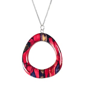 May include: A silver chain necklace with a large, red, blue and gold oval pendant. The pendant is made of resin and has a marbled pattern.