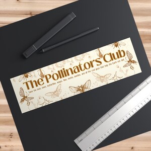 May include: A beige sticker with brown illustrations of bees, butterflies, moths, and other insects. The text "The Pollinators Club" is in brown lettering and the text "Save the bats, bees, butterflies, wasps, flies, moths, beetles, and all the cool guys that help the Earth not die!" is in smaller brown lettering.