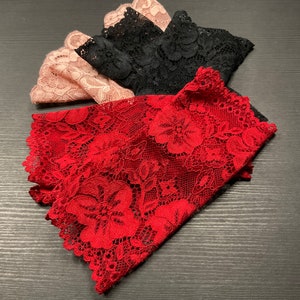 以下が含まれることがあります： 赤、黒、ピンクのレース生地のサンプル3枚。赤いレースは花柄です。