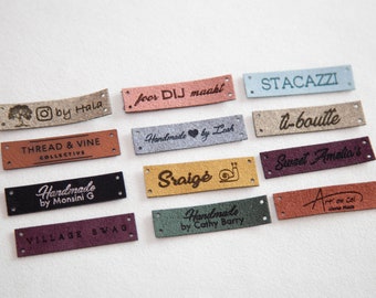 May include: A collection of 11 different leather labels with various text and designs. The labels are in different colors, including brown, beige, gray, blue, green, and red. The text on the labels includes "Thread & Vine Collective", "Handmade by Monsini G", "Sraigė", "Sweet Amelia's", "Village Swag", "Handmade by Cathy Barry", "O by Hala", "foor DIJ maakt", "STACAZZI", "U-boulte", and "Art on Col".