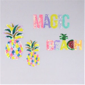 Può includere: Due toppe di ananas colorate e due toppe che dicono "MAGIC" e "BEACH" con una fetta di anguria nella "H".
