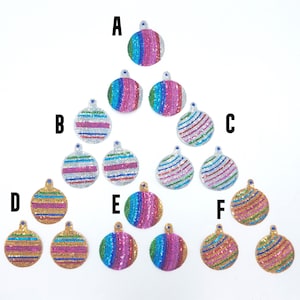 May include: Assortment of 12 colourful beaded Christmas baubles in various patterns and colours, including gold, silver, pink, blue, and green. The baubles are arranged in a triangular pattern with letters A through F labelling each row.
