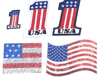 May include: A selection of patriotic sequin patches. The patches feature the American flag and the number "1". The patches include the flag in a rectangular and waving design, and the number "1" with red and white stripes and the word "USA".
