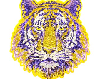 May include: A yellow and purple sequined tiger head applique. The tiger's face is detailed with purple stripes and a pink nose.