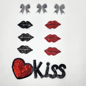 May include: A set of iron-on patches featuring red and black lips, silver bows, and a red heart with the word "kiss" in black sequins.