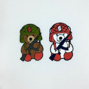 May include: Two embroidered patches of teddy bears wearing military helmets and holding rifles. The bear on the left is brown and the bear on the right is white.