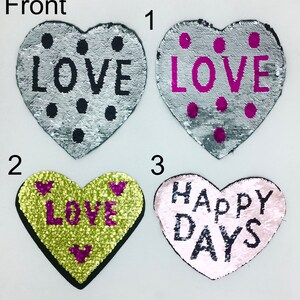 May include: Four heart-shaped sequin patches with different messages. The first two patches are silver with black dots and the word "LOVE" in black. The third patch is yellow with pink dots and the word "LOVE" in pink. The fourth patch is pink with black dots and the words "HAPPY DAYS" in black.