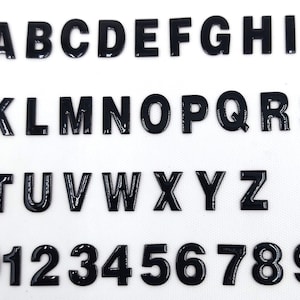 May include: Black plastic letters and numbers, from A to Z and 0 to 9. The letters and numbers are uppercase and are all the same size.
