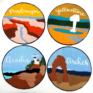 Puede incluir: Cuatro tapices redondos, coloridos y bordados con los nombres de los parques nacionales: Gran Cañón, Yellowstone, Acadia y Arches.