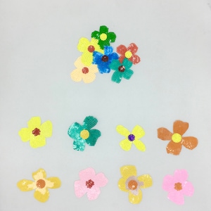 May include: Assortment of colorful sequin flower patches in various colors including yellow, green, blue, pink, and brown. The patches are perfect for adding a touch of whimsy to clothing, bags, or other accessories.