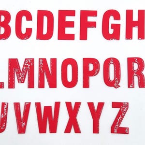 May include: Red plastic letters of the alphabet, A through Z, in a white background.