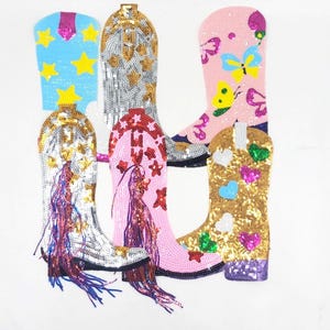 May include: A selection of sequined cowboy boot patches in various colours. Boots include blue with yellow stars, silver with gold accents, pink with butterflies, and gold with hearts. Some boots have decorative fringe.