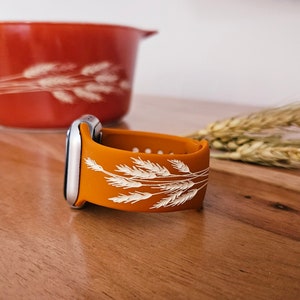 K&ouml;nnte beinhalten: Orangefarbenes Silikonarmband f&uuml;r Apple Watch mit einem wei&szlig;en Weizenmuster.