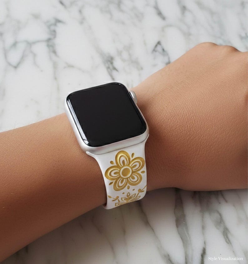 An AI-generated lifestyle mockup showing a white silicone Apple Watch band with a Pyrex Buttefly Gold  floral pattern on a model's wrist, displayed over a white marble background to show scale and fit.