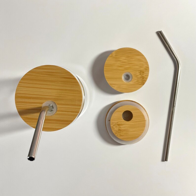 May include: A set of three bamboo lids with a stainless steel straw. The lids have a hole in the center for the straw. The straw is bent at a 90-degree angle.