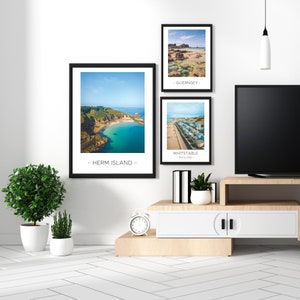 Puede incluir: Tres fotograf&iacute;as enmarcadas de escenas costeras con los nombres de las ubicaciones impresos debajo de cada imagen. Las im&aacute;genes est&aacute;n colgadas en una pared blanca sobre un centro de entretenimiento de madera con un gabinete blanco y un televisor negro.