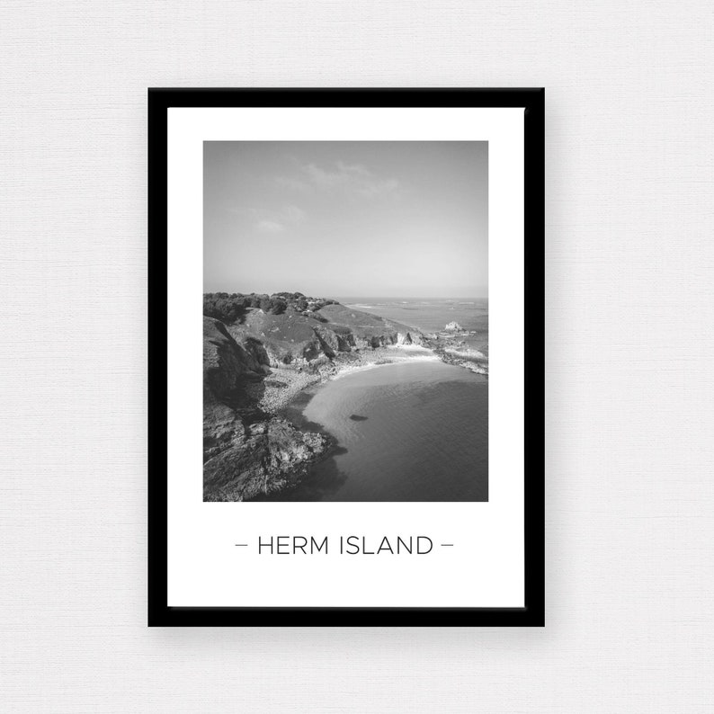 Puede incluir: Fotograf&iacute;a en blanco y negro de una costa rocosa con una peque&ntilde;a playa y el texto "Herm Island" en la parte inferior.
