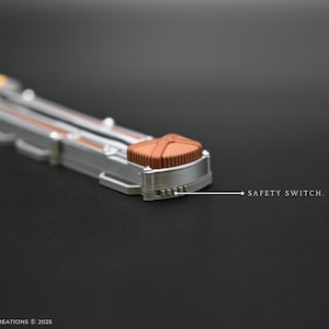 K&ouml;nnte beinhalten: Ein silbernes und braunes Metallobjekt mit einem Sicherheitsschalter mit der Aufschrift "SAFETY SWITCH."