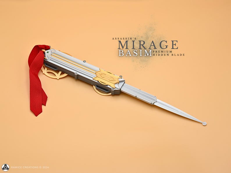 May include: A silver and gold hidden blade with a red ribbon. The blade is labeled "Assassin's Mirage Basim Premium Hidden Blade".