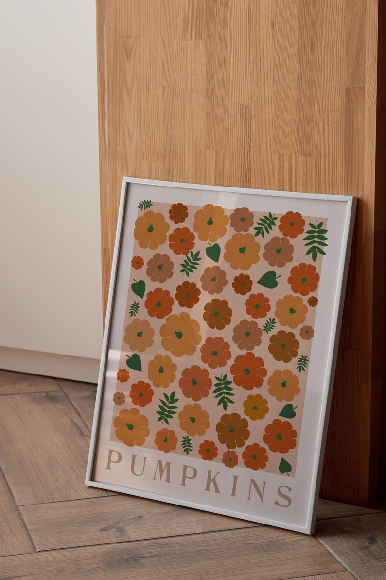 May include: A white framed print featuring a pattern of orange and brown pumpkins and green leaves on a light peach background. The text "PUMPKINS" is at the bottom of the print.