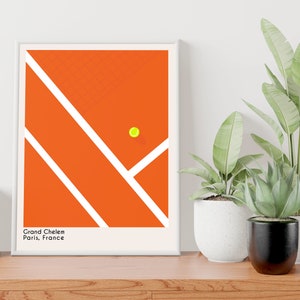 May include: A minimalist poster with a graphic design of a tennis court in orange with white lines and a yellow tennis ball. The text "Grand Chelem Paris, France" is at the bottom of the poster.
