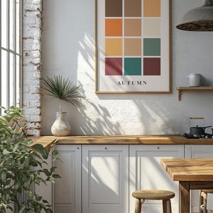 May include: A framed print with a grid of 12 colored squares in shades of brown, orange, yellow, green, and red. The word "AUTUMN" is printed below the grid.