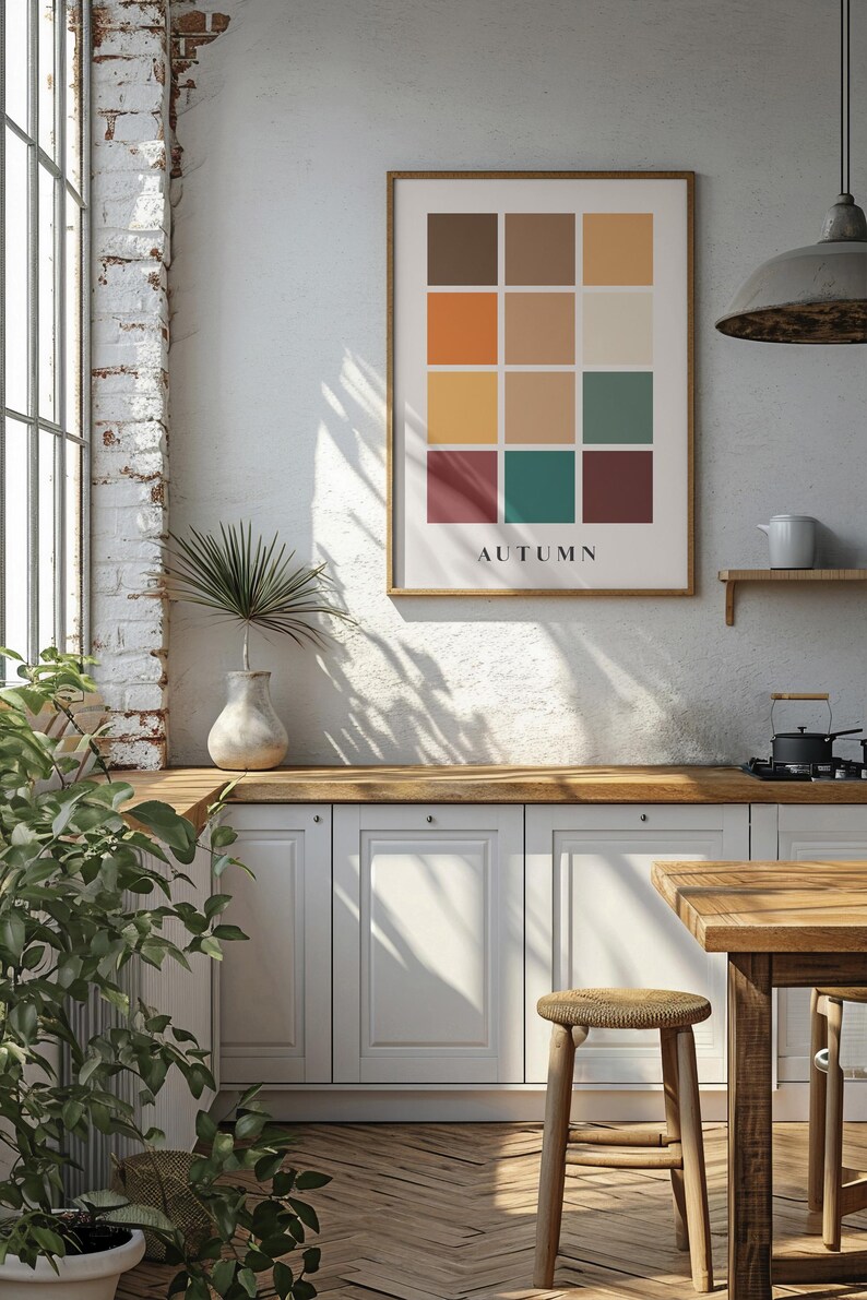 May include: A framed print with a grid of 12 colored squares in shades of brown, orange, yellow, green, and red. The word "AUTUMN" is printed below the grid.