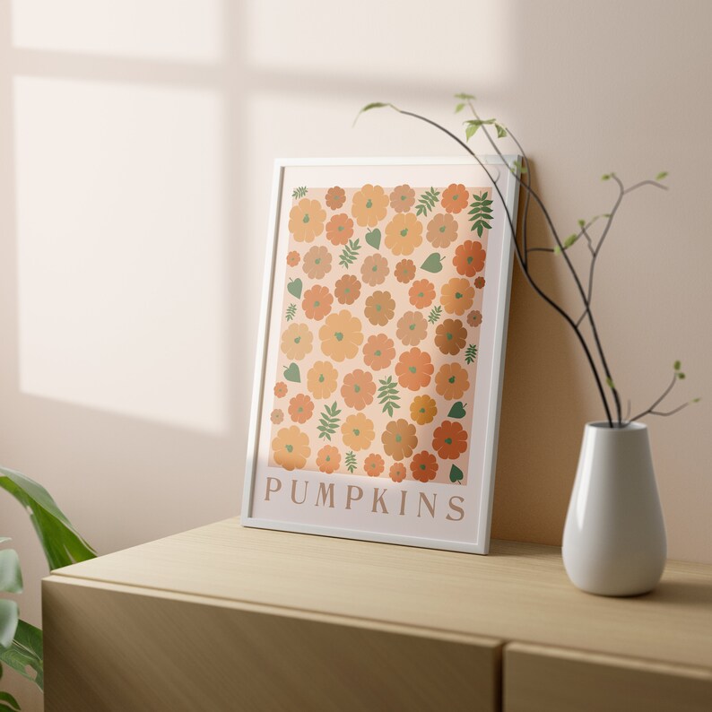 May include: A white framed print featuring a pattern of orange and brown pumpkins and green leaves. The print has the word "PUMPKINS" at the bottom.