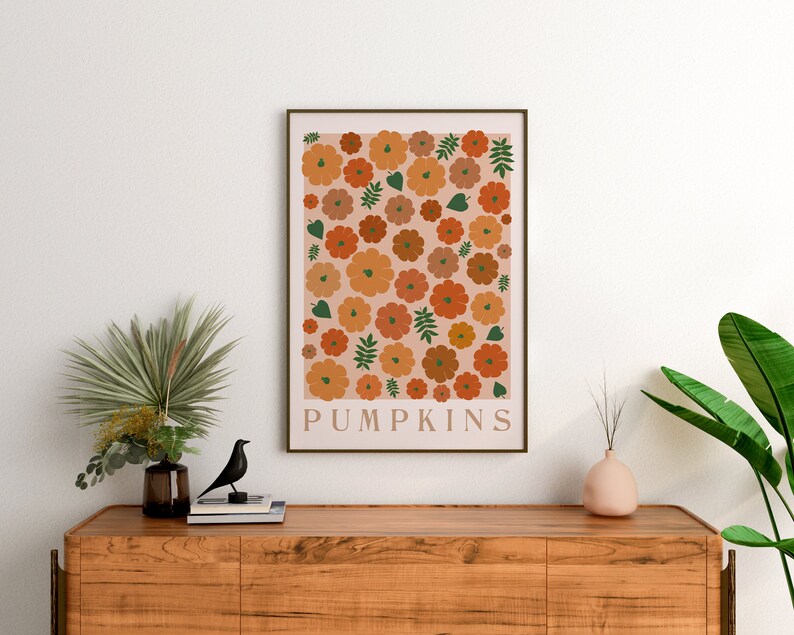 May include: A digital print featuring a pattern of orange and brown pumpkins with green leaves on a pale pink background. The print has the word "PUMPKINS" at the bottom.