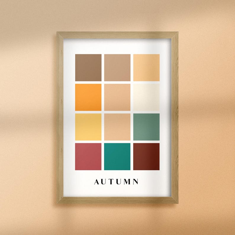 May include: A framed print with a color palette of 12 squares in shades of brown, orange, yellow, green, and red. The word "AUTUMN" is printed below the squares.