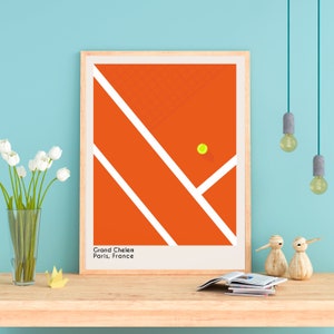 May include: A minimalist poster with a graphic design of a tennis court in orange and white with a yellow tennis ball. The text "Grand Chelem Paris, France" is at the bottom of the poster.