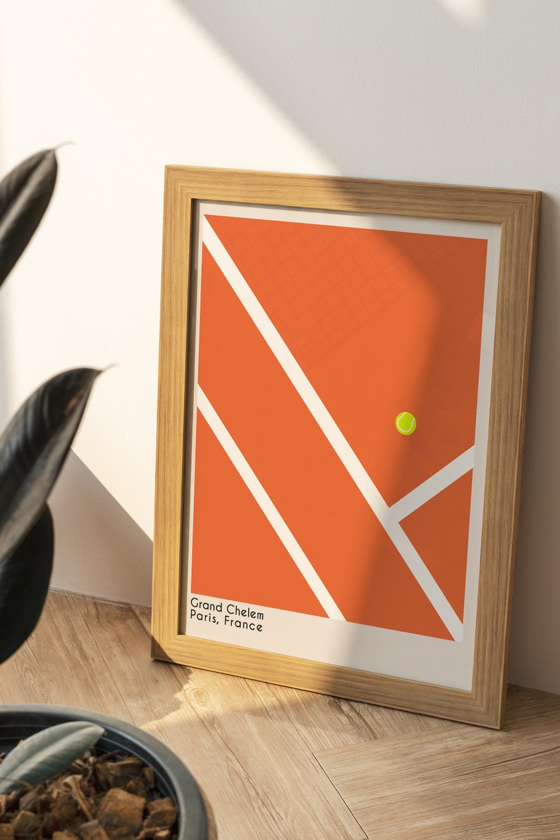 May include: A framed print of a tennis court with a yellow tennis ball in the center. The court is orange with white lines. The text "Grand Chelem Paris, France" is at the bottom of the print.