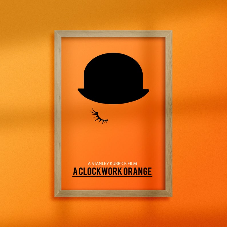 Puede incluir: Un p&oacute;ster minimalista con una silueta negra de un bomb&iacute;n y un ojo con una pesta&ntilde;a. El p&oacute;ster tiene un fondo naranja brillante y un marco de madera. El texto "A Stanley Kubrick Film A Clockwork Orange" est&aacute; impreso en negro en la parte inferior del p&oacute;ster.