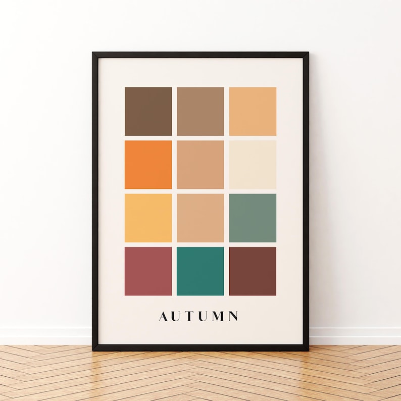 May include: A framed print with a color palette of 12 squares in shades of brown, orange, yellow, green, and red. The word "AUTUMN" is printed in black at the bottom of the print.