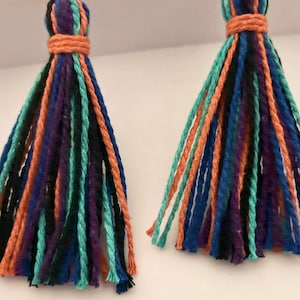 May include: A pair of colorful tassel earrings with a mix of orange, blue, green, black, and purple yarn.