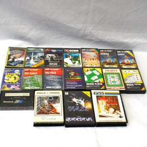 May include: A collection of seventeen vintage computer software cassette tapes in their original plastic cases. The titles include Cassette 50, VU-Calc, VU-File, Bridge Player, Eights, Bridge Tutor, Halls & Things, and Quicksiva, featuring colourful graphic art.