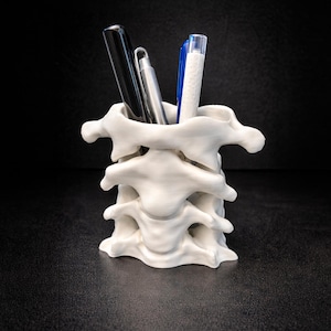 Peut inclure: Ensemble de trois tasses en céramique avec une finition mate et mouchetée. Les tasses sont de couleur crème, gris clair et gris foncé. Chaque tasse a un design simple et minimaliste, idéal pour le café ou le thé.