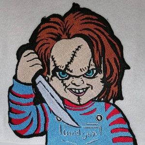 Op de afbeelding: Gestikt patch met een cartoonfiguur met rood haar, die een mes vasthoudt en een blauw-rood gestreept shirt draagt met de tekst "Good Guys" op de voorkant.