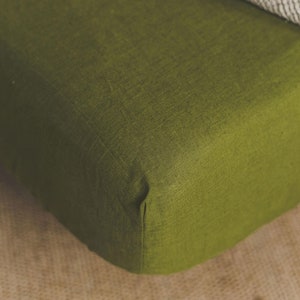 Peut inclure: Un gros plan sur un drap housse vert en tissu de lin. Le drap est plié et a une surface lisse et texturée.